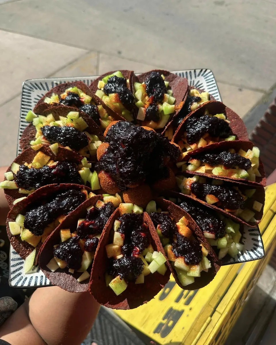 Tray of fruit tacos with homemade chamoy arranged like a flower