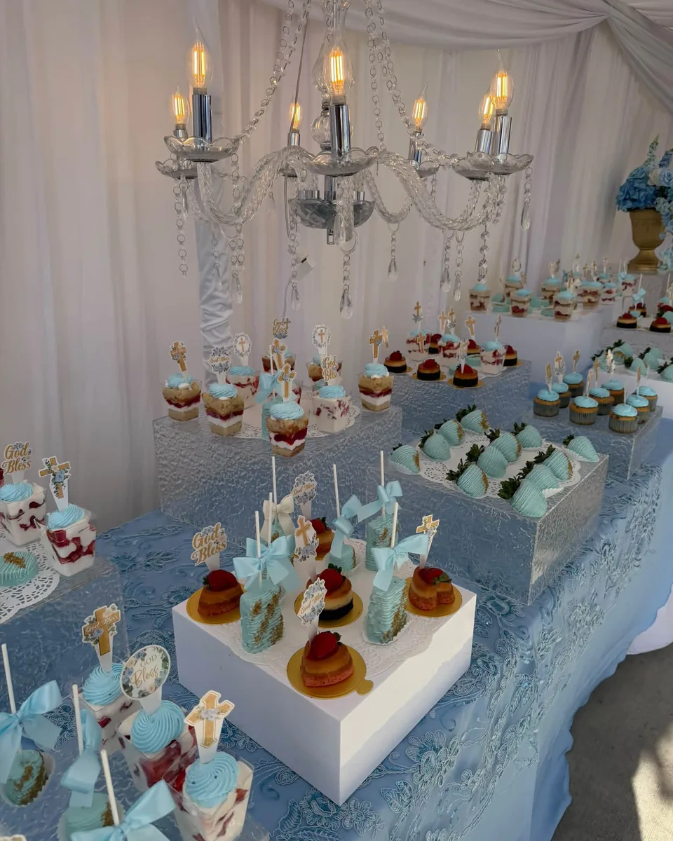 Powder blue bautizo dessert table under crystal chandeliers