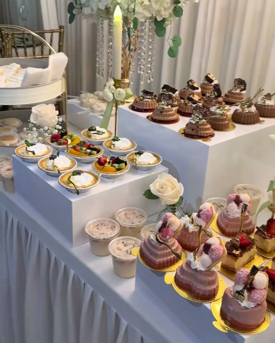 Elegant wedding dessert table with chandelier and individual desserts
